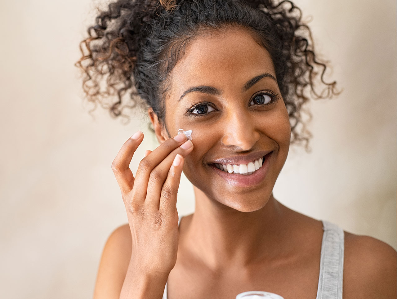 Young woman with youthful skin doing a skincare routine.