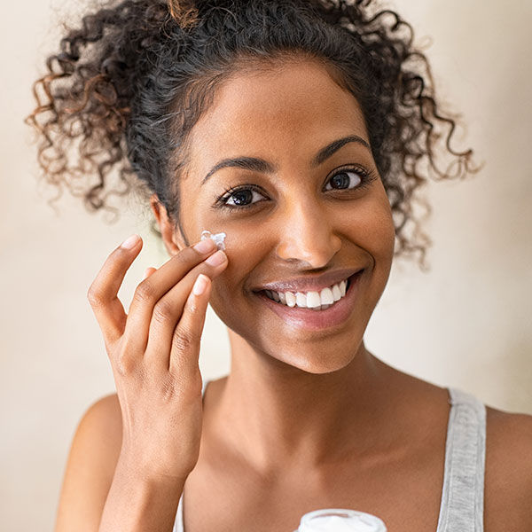 Young woman with youthful skin doing a skincare routine.