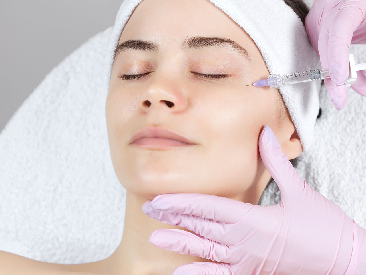 Woman receiving Xeomin treatment around her cheek and eye area.